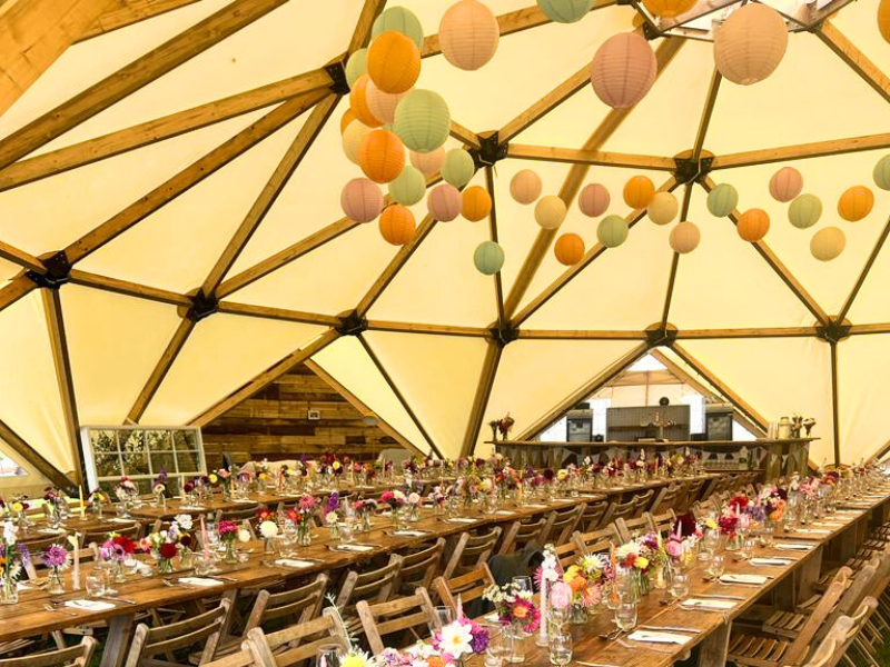 internal photo of geodome set with tables and decorated with lanterns